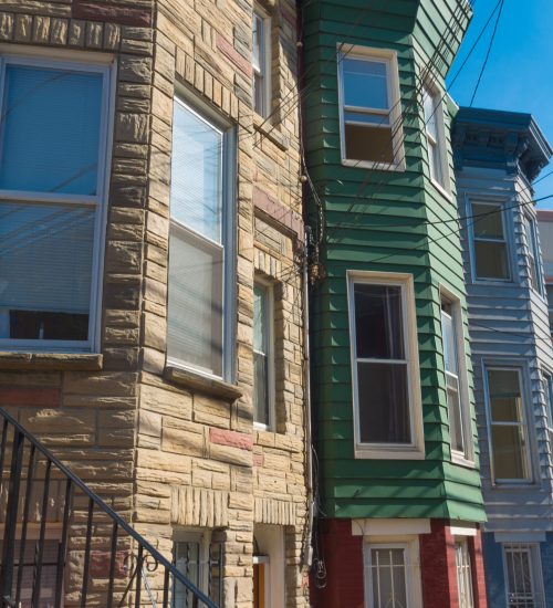 facades of typical american townhomes with front stairs in jersey city