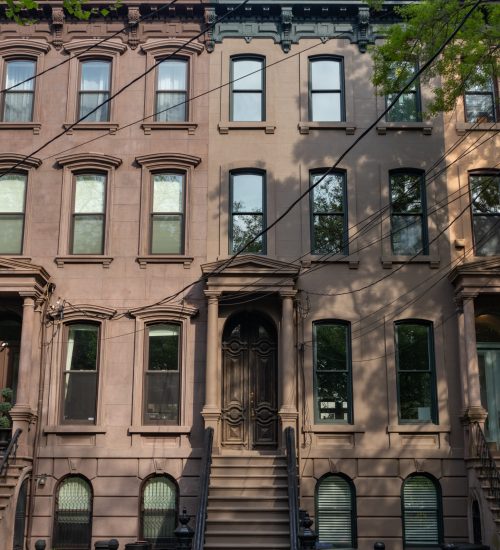 Row of Beautiful Old Brownstone Homes with Staircases along an Empty Sidewalk in Jersey City New Jersey